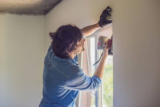 istock Man in a blue shirt does window installation 860487178