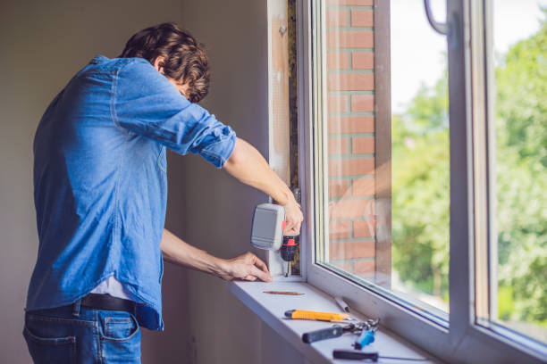 istock Man in a blue shirt does window installation 860487186