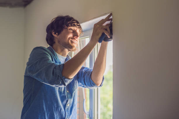 istock Man in a blue shirt does window installation 860487198
