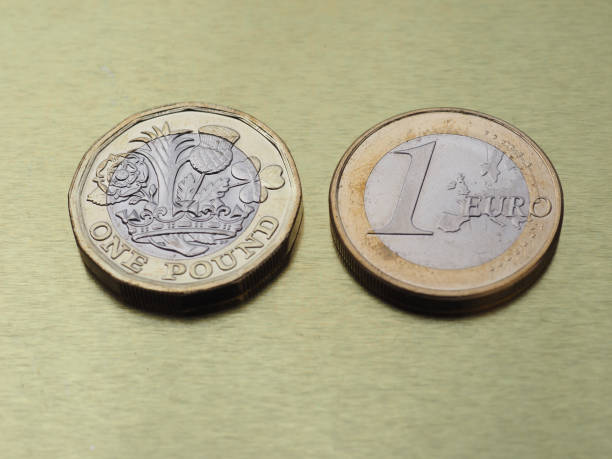 istock 1 pound and 1 euro coin over metal background 860488006