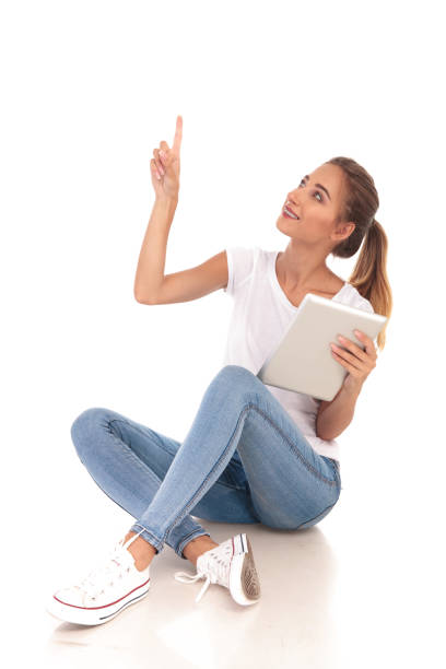 istock happy casual woman holding tablet and points up 860488266