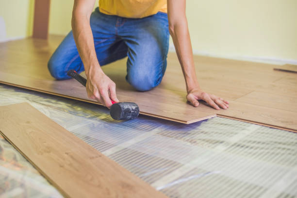 istock Man installing new wooden laminate flooring. infrared floor heating system under laminate floor 860488302