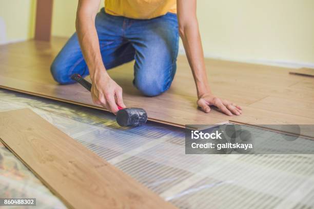 Man Installing New Wooden Laminate Flooring Infrared Floor Heating System Under Laminate Floor Stock Photo - Download Image Now