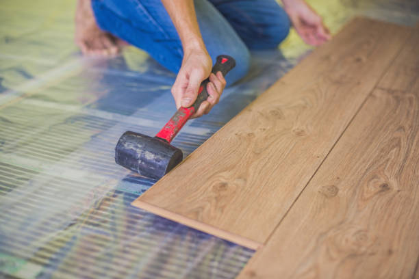 istock Man installing new wooden laminate flooring. infrared floor heating system under laminate floor 860488316
