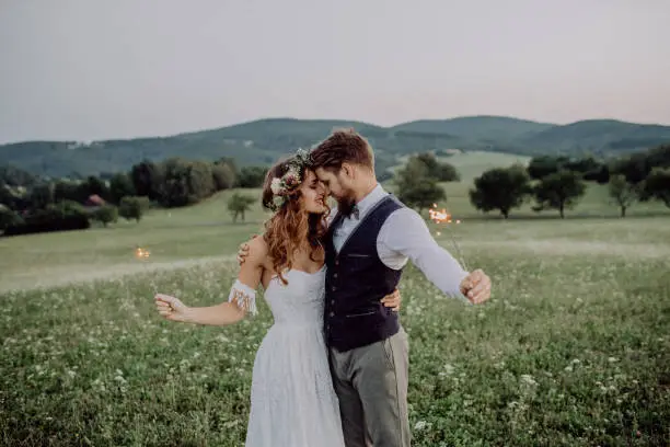 Photo of Beautiful bride and groom at sunset in green nature.