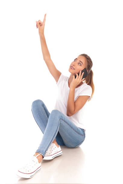 istock smiling woman talking on the phone is pointing up 860488748