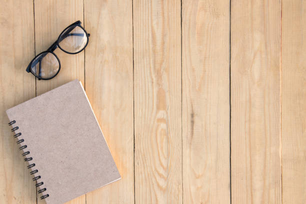 istock Book and eyeglasses on brown wooden table. copy space 860492018