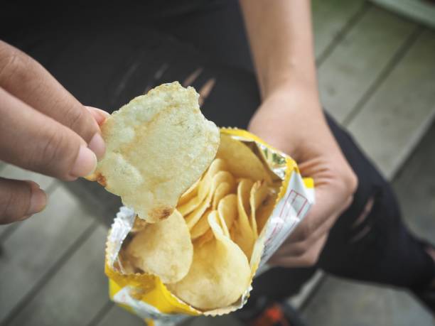 istock Woman eating potato chip 860492368