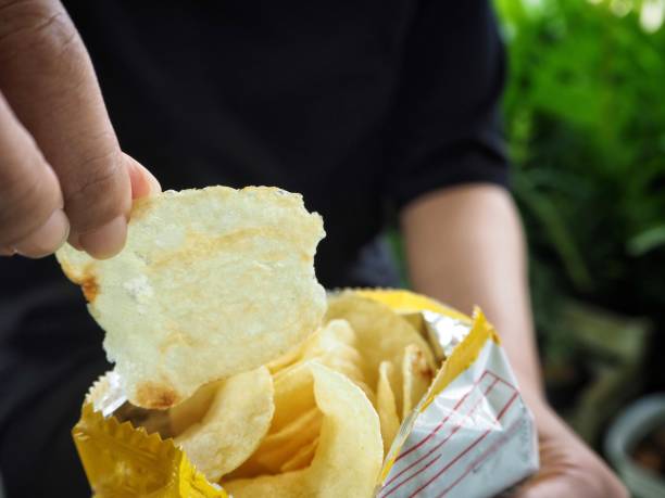istock Woman eating potato chip 860492644