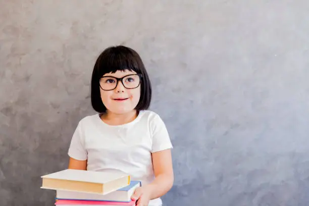 Portrait of cute blackhair little girl with books