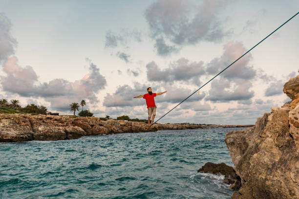 istock Man practicing slacklining over the sea in Minorca Spain 860499602