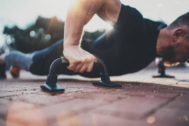istock Healthy workout lifestyle concept.Training outdoors.Handsome sport athlete man doing pushups in the park on the sunny morning. Blurred background. 860499716