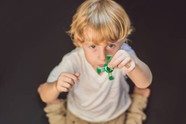 istock Young boy play with fidget spinner stress relieving toy 860500542