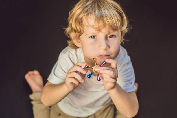 istock Young boy play with fidget spinner stress relieving toy 860500566