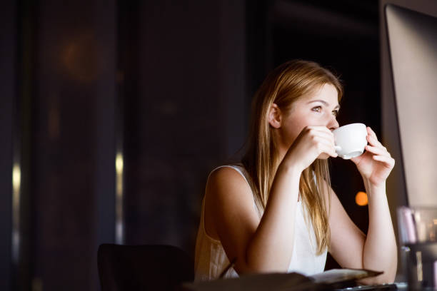 istock Businesswoman in front of computer screen in office at night. 860503076