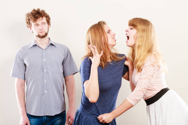 istock Aggressive mad women fighting over man. 860508174