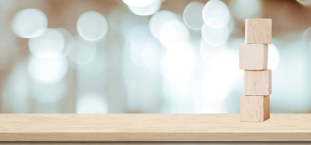 istock Four wooden cubes on table over blur abstract bokeh light background, banner with copy space for text 860516072