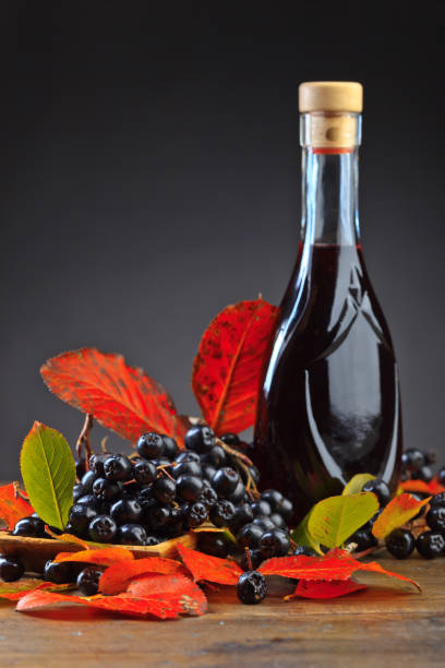 istock Black chokeberry and bottle with juice . 860520750