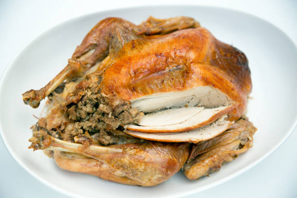 istock roast turkey sliced with stuffing isolated on white platter 860524742