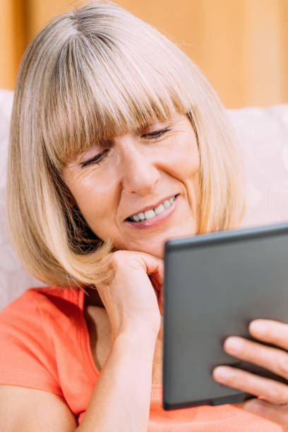 istock Senior woman reading ebook 860525202