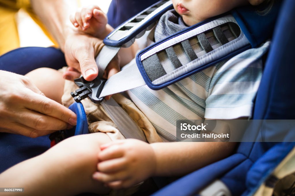 Cinturón de seguridad de fijación de padre a su hijo sentado en el coche. - Foto de stock de Bebé libre de derechos