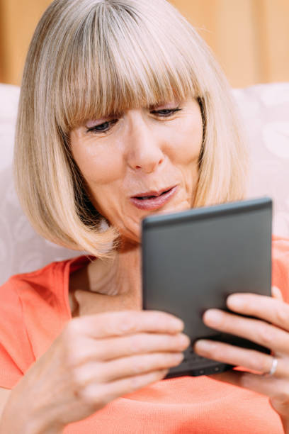 istock Senior woman reading ebook 860528872