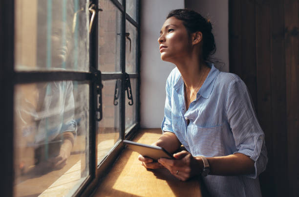 istock Woman standing by office window with digital tablet 860532168