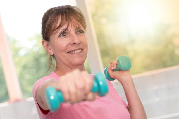 istock Woman exercising with dumbbells, light effect 860534108