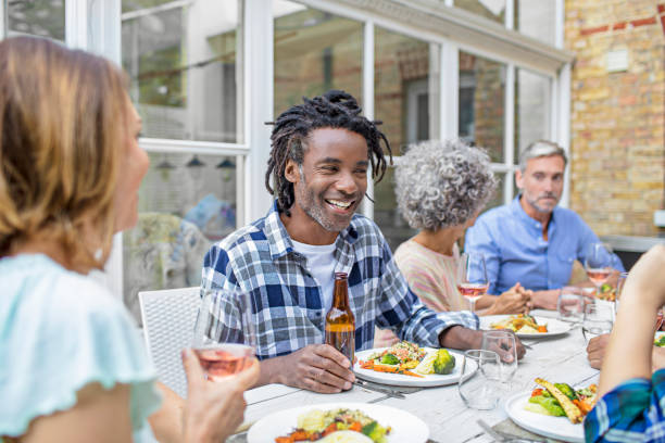 istock Smiling man having lunch with friends in backyard 860534114