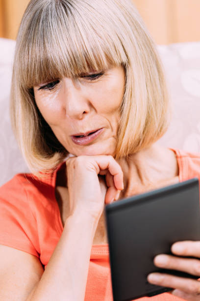 istock Senior woman reading ebook 860536856