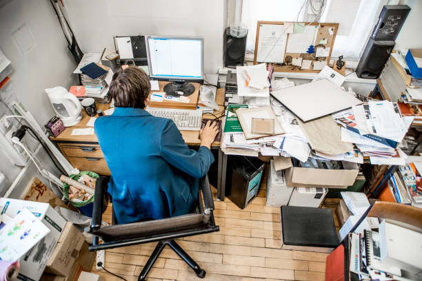 widok wysokiego kąta pracownika biurowego pracującego na komputerze - chaos zdjęcia i obrazy z banku zdjęć