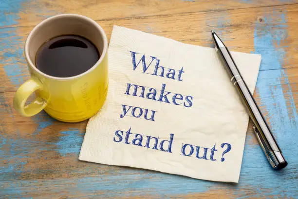 What make you stand out? Handwriting on a napkin with a cup of espresso coffee