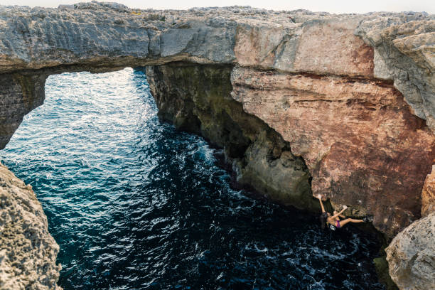 istock Woman practicing deep water solo rock climbing 860541658