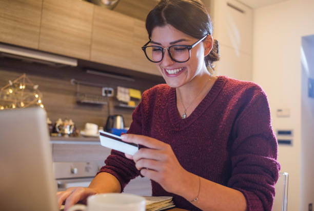 hermosa joven de compras online desde casa - vale de regalo fotografías e imágenes de stock