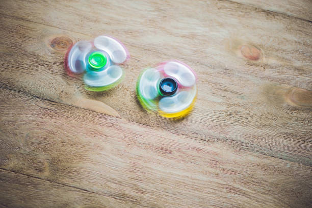 istock Colored fidget spinners stress relieving toy on wooden background 860548368
