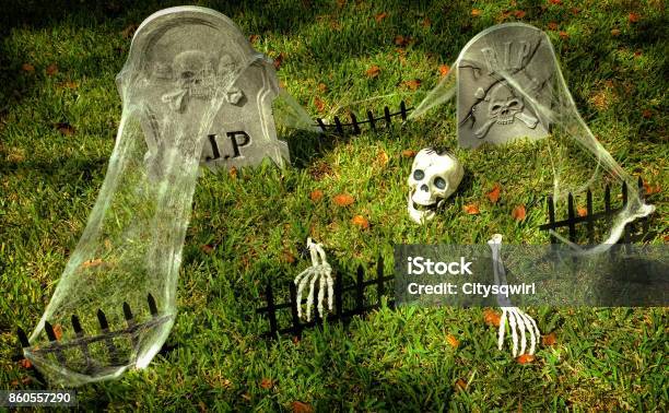 Halloween Decorations Of A Skeleton With A Spider On Its Head Climbing Out Of A Grave Stock Photo - Download Image Now