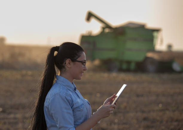 istock Agronomist with tablet and combine harvester 860574176
