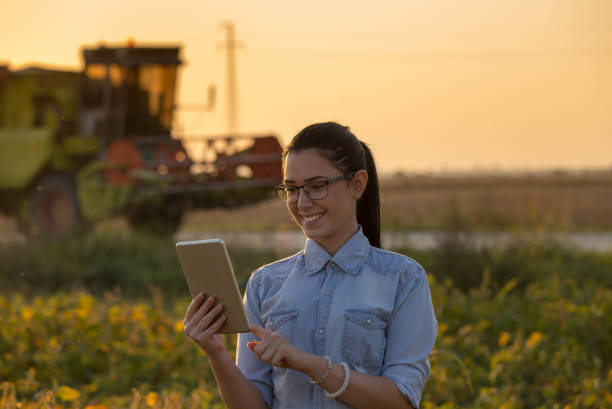 istock Agronomist with tablet and combine harvester 860574190