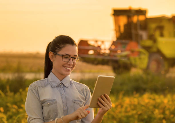 istock Agronomist with tablet and combine harvester 860574594
