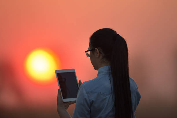 istock Woman with tablet at sunset 860575586