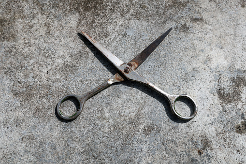 The old iron scissors are located on a stone surface