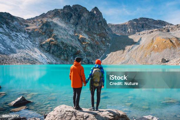 Pareja De Turistas Se Ve En El Lago Luna De Miel En Los Alpes Hermoso Lago De Color Turquesa En Las Montañas Foto de stock y más banco de imágenes de Parejas