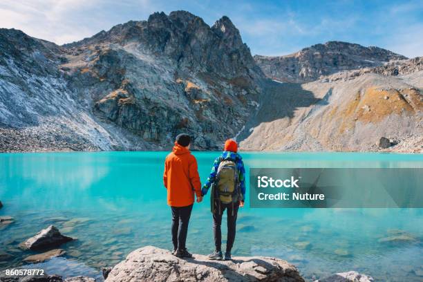 Couple Of Tourists Looks At The Lake Honeymoon In Alps Beautiful Turquoise Lake In The Mountains Stock Photo - Download Image Now