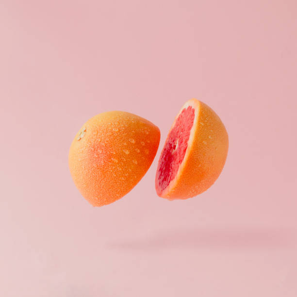 grapefruit sliced on pastel pink background. minimal fruit concept. - grapefruit fruit freshness pink imagens e fotografias de stock