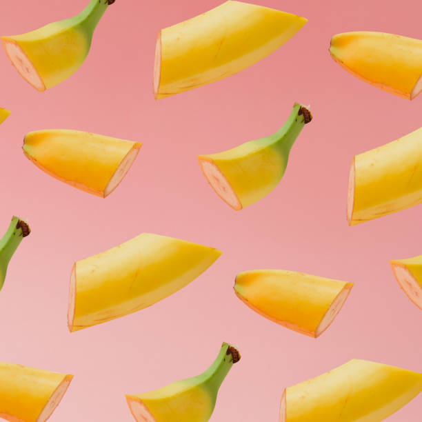 Banana slice pattern on pastel pink background. Minimal fruit concept.