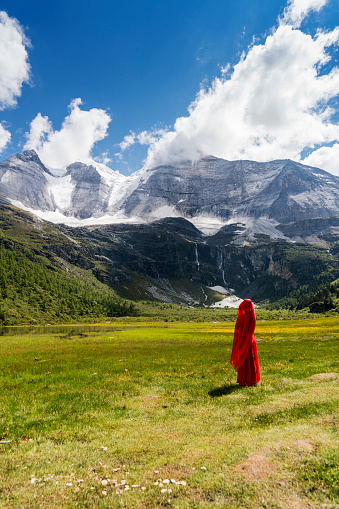 A female traveller was standing in the canyon,Daocheng County, Sichuan province, China.