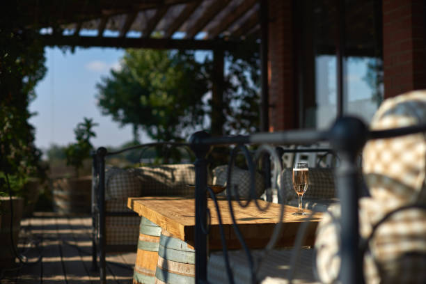 istock Cozy terrace with sofas for rest, Glass with champagne on a wooden table. 860598274