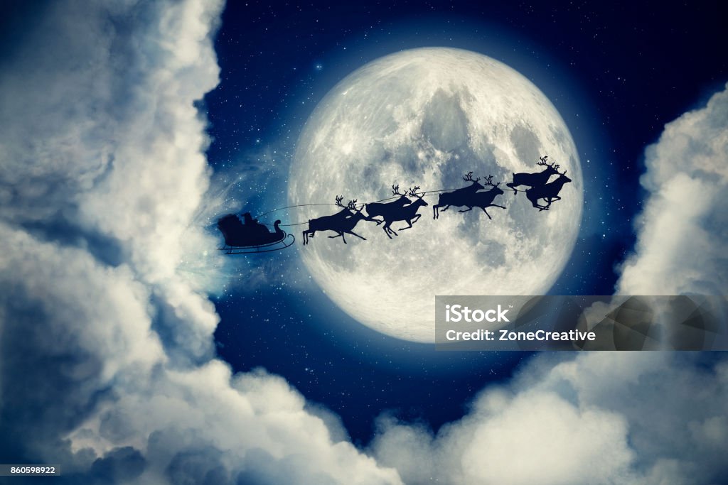 Blue xmas eve night with moon and clouds with Santa Claus sleight and reindeer silhouette flying to bring gifts and presents with text space to place logo or copy. Christmas present greeting post card Blue xmas eve night with moon and clouds with Santa Claus sleight and reindeer silhouette flying to bring gifts and presents with text space to place logo or copy. Christmas present greeting post card. Santa Claus Stock Photo