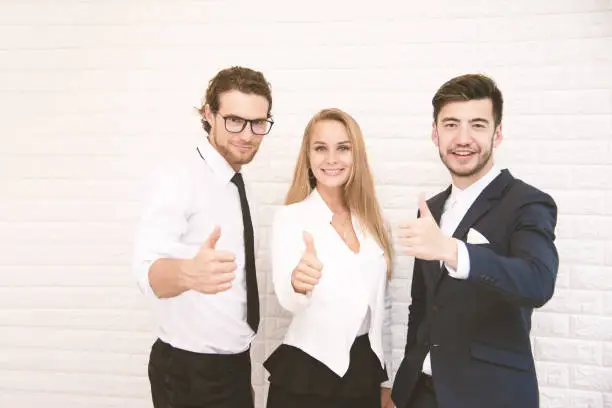 Team workers thumbs up for success in business in front of wall at cafe, Business and success concept, Teammate and Cooperation, Soft tone pinterest and instragram like process.