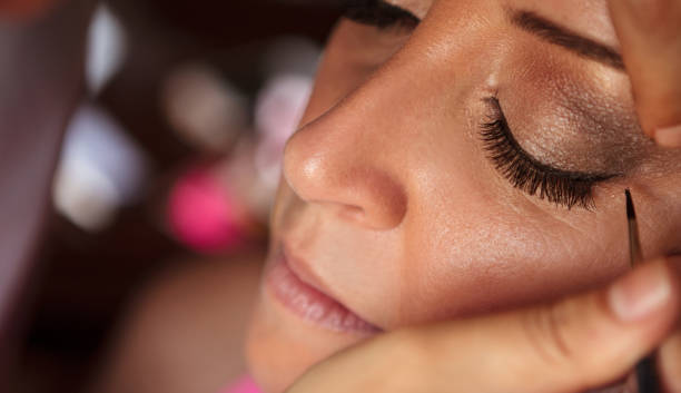 beautiful fashion model applying makeup by makeup artist. - brushing women make up ceremonial makeup imagens e fotografias de stock